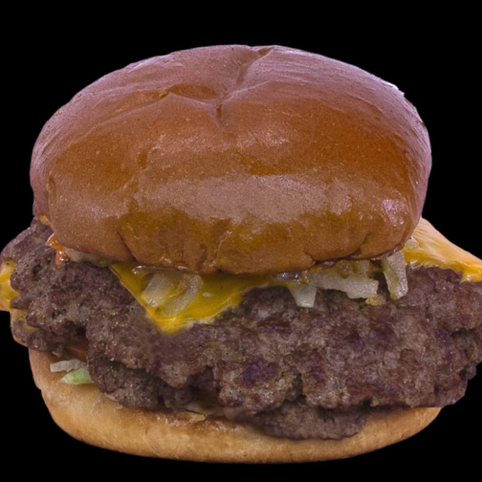 A double cheeseburger with melted cheese, grilled onions, and lettuce on a toasted bun.